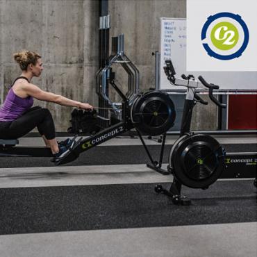 Athlete on a RowErg in a Gym with BikeErg in Foreground