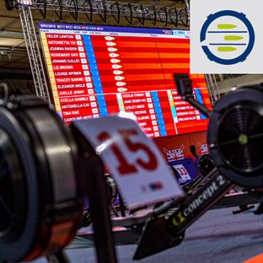 Indoor Race Showing RowErgs and Large Screen of Results