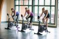 Three People on BikeErgs in a Gym