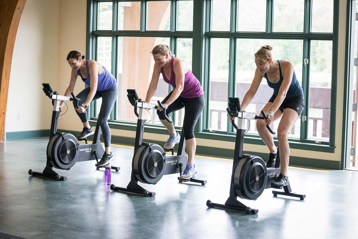 Three People on BikeErgs in a Gym